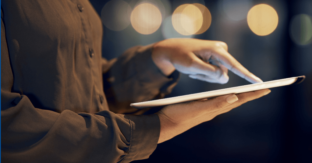 Person holding a tablet and pointing to a section on the screen.