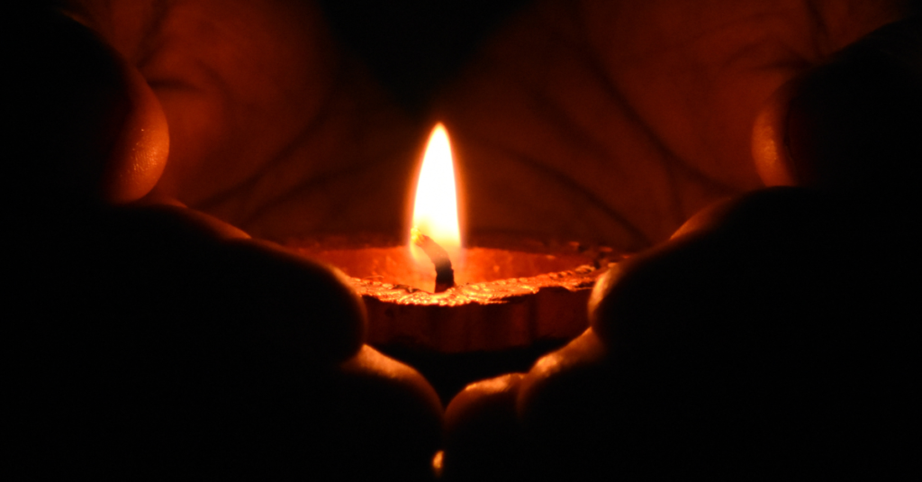 Person holding a lit candle.