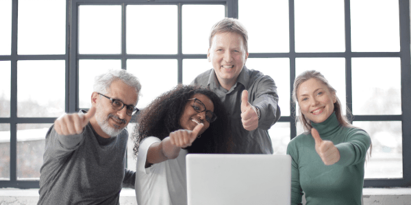 Give professional people in an office setting giving the thumbs up.