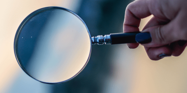 Person holding a magnifying glass.