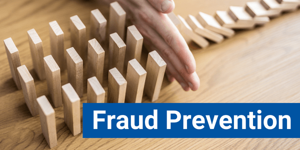 Hand preventing dominos from falling down. There is text that says 'Fraud Prevention.'